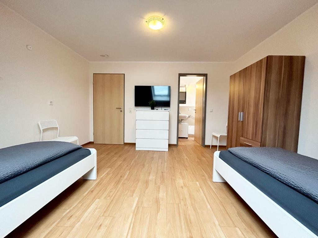 a bedroom with two beds and a flat screen tv at Nice Apartment in Büchenberg in Eichenzell