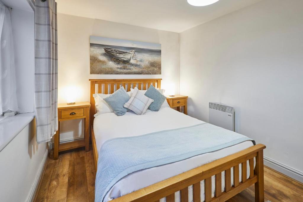 a bedroom with a bed and a painting on the wall at Host & Stay - Camwy Cottage in Brynsiencyn