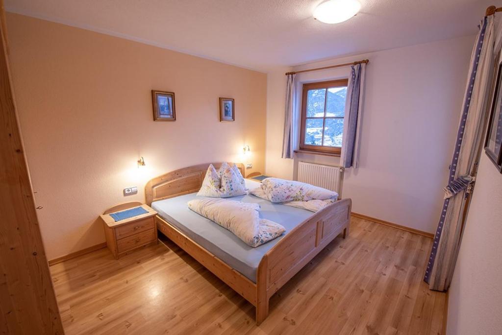 1 dormitorio con cama y ventana en Patztauhof Wohnung Tschavalatsch, en Sluderno