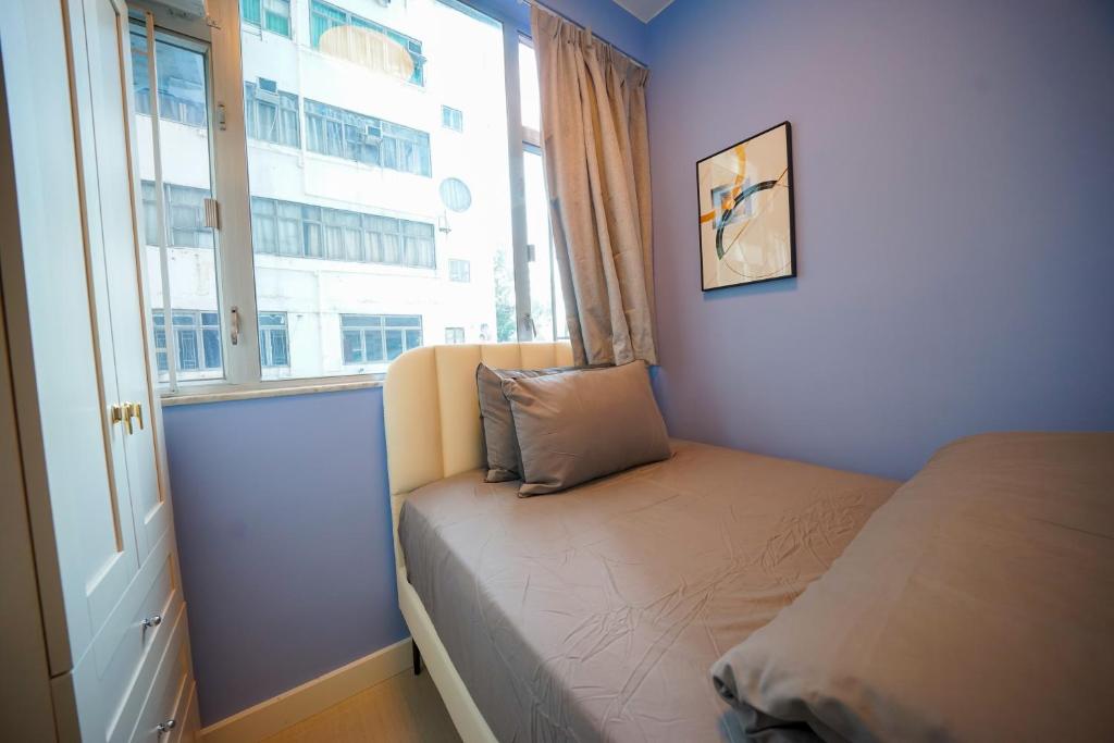 Un dormitorio pequeño con una cama y una ventana. en Student Accommodation - 276 Gloucester Road, en Hong Kong