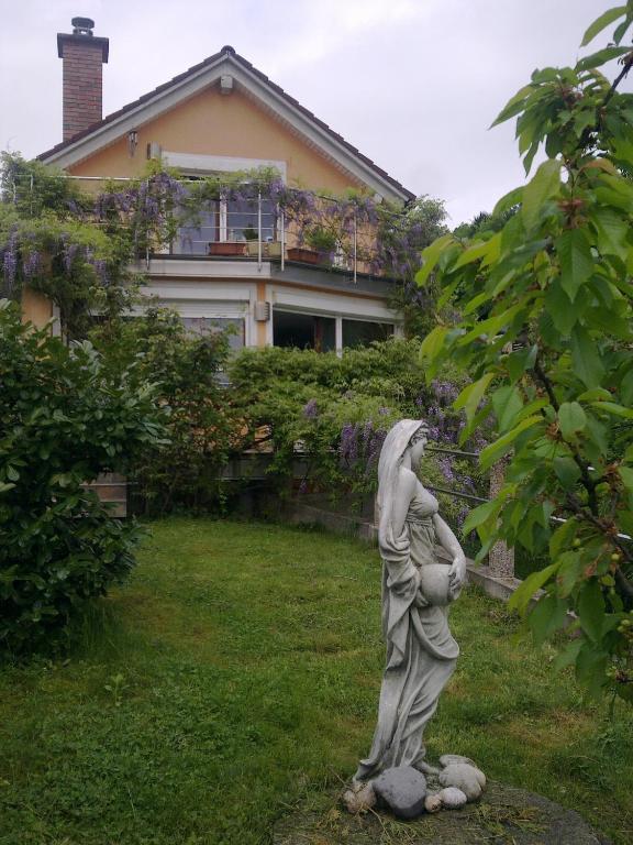 a statue of a woman standing in a yard at ANERI in Ljubljana