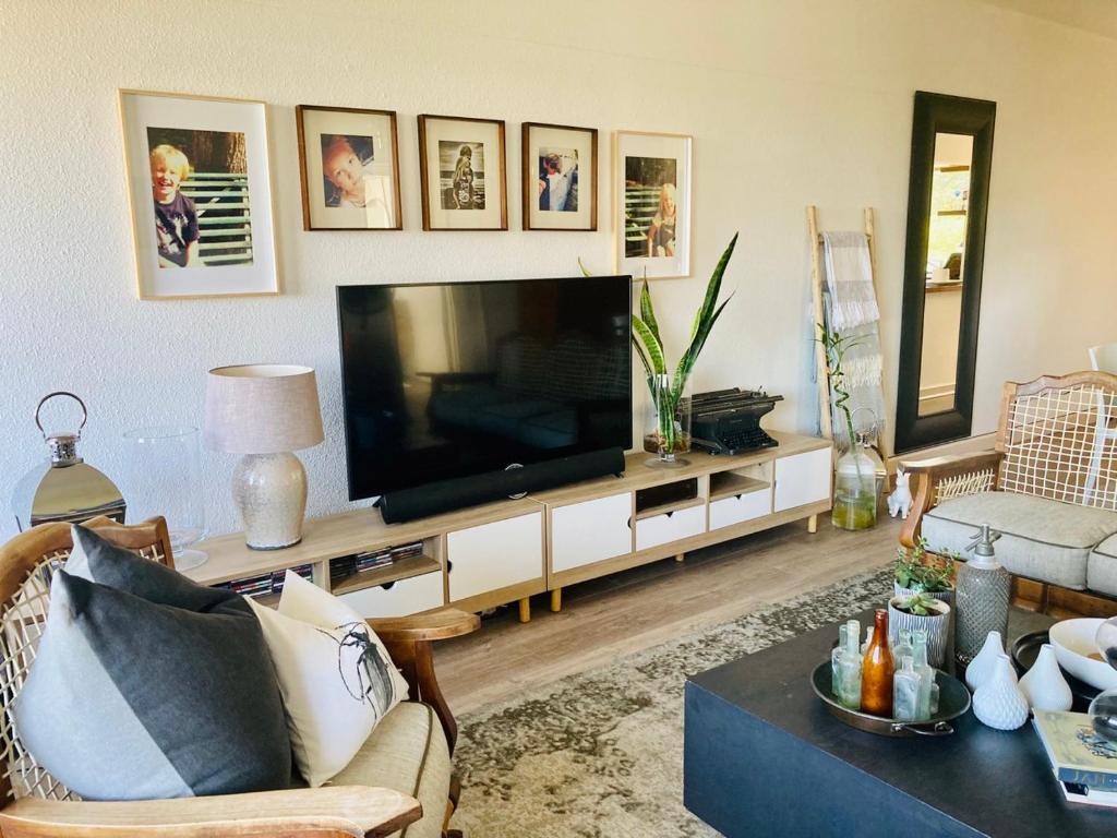 a living room with a flat screen tv on a entertainment center at 504 on Wilderness in Cape Town
