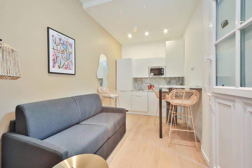 un salon avec un canapé et une cuisine dans l'établissement 0#Appart 4Pers#1 Bedroom#Paris 15#Commerce#AC, à Paris