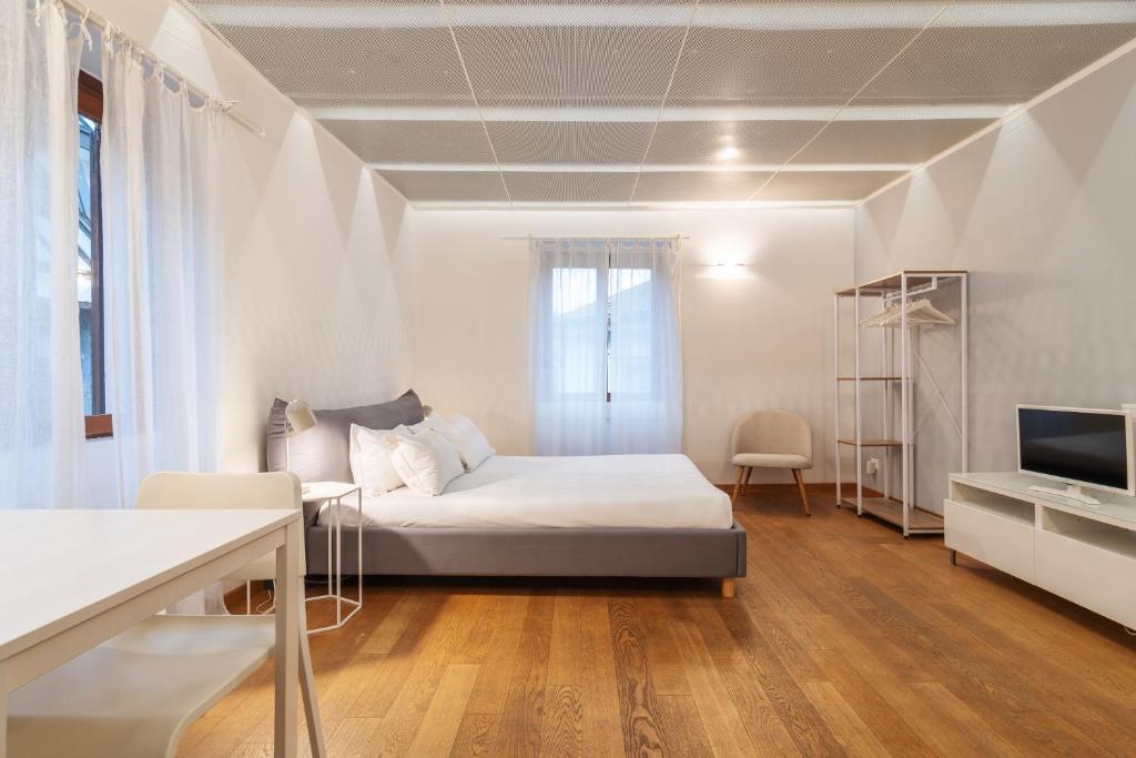 ミラノにあるeasyhomes - Spiga Suiteの白い部屋(ベッド1台、テレビ付)