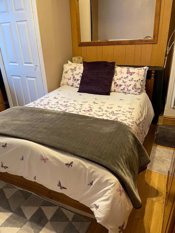 a bedroom with a bed with flowers on it at ROOM with SHOWER, TOILET and KITCHENETTE in Tonbridge