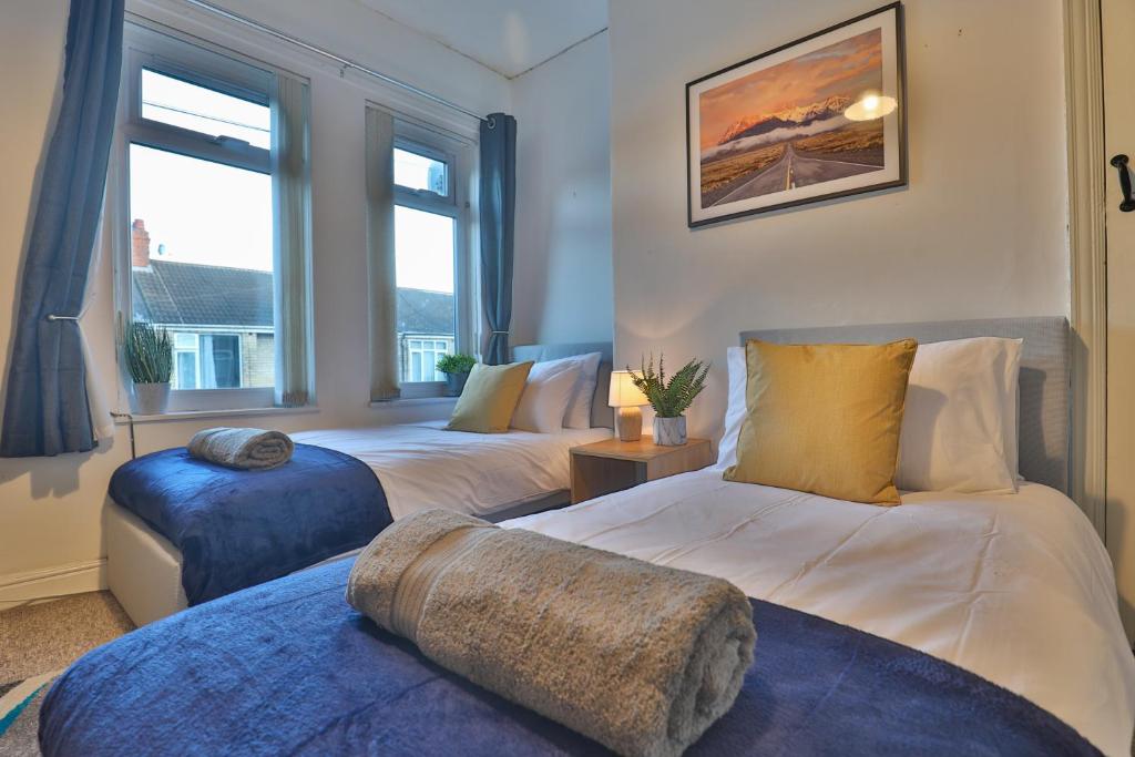 2 camas en una habitación con 2 ventanas en ZSKstays! Comfortable home, 10 minutes from centre, free parking!, en Hull