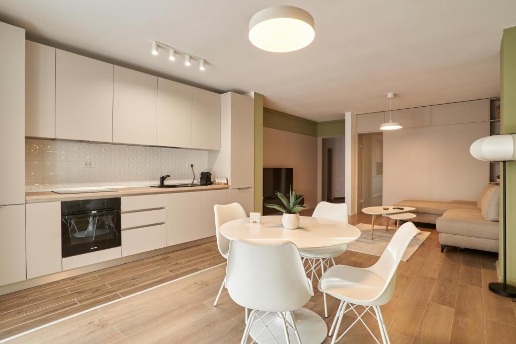 a kitchen and living room with a table and chairs at Alternativ 3 Residence Central in Timişoara