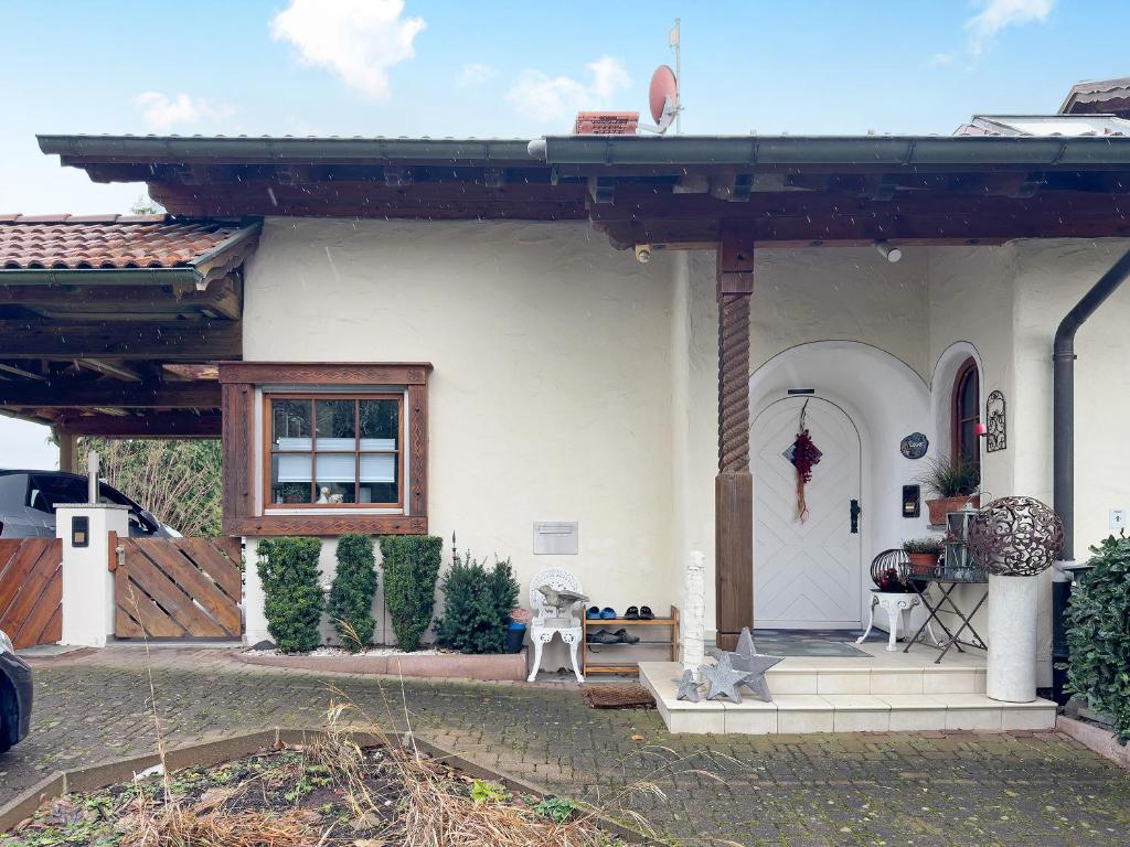 a white house with a porch and a window at Haus Loser in Wasserburg