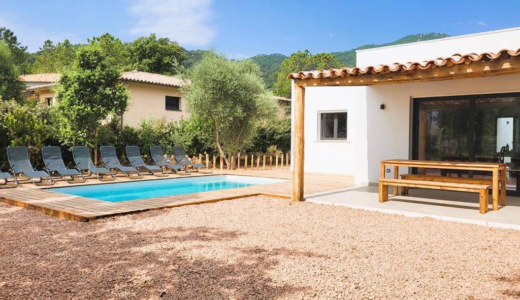 Cette villa dispose d'une piscine avec des chaises et une table. dans l'établissement Villa Bruna, 8 pers, piscine, 15 minutes plage en voiture, à Capo