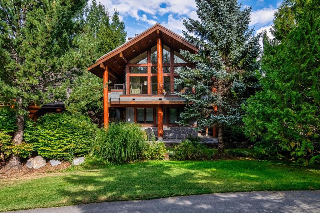 a home with a large wooden house at Glacier View Chalet - Tranquil Chalet with Private Hot Tub & Golf Course Views - Whistler Platinum in Whistler