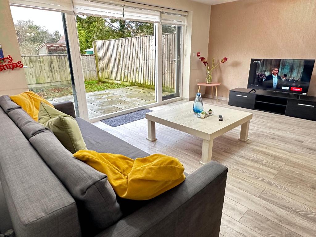 a living room with a couch and a table at Horizon House, Stunning 2-Bedroom Flat 1, Parking, Netflix, Oxford in Oxford