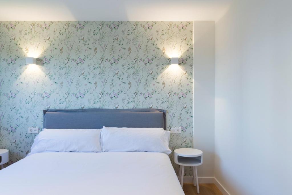a bedroom with a bed and two lights on the wall at PAKELEKU in San Sebastián