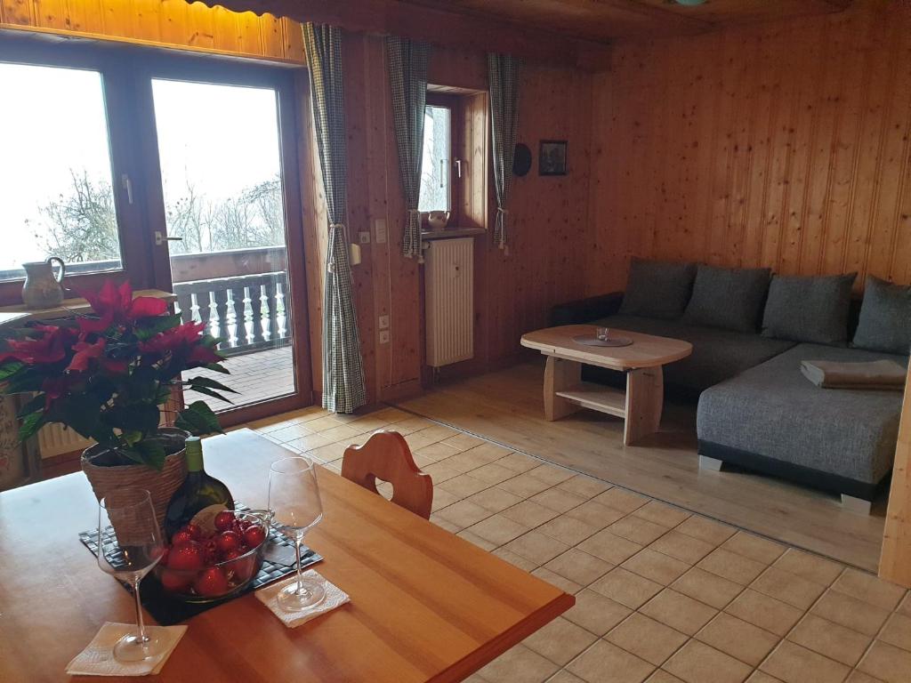 uma sala de estar com um sofá e uma mesa em Uriges Apartment + Schönblick + mitten im Bayerischen Wald + WLAN kostenfrei em Schöfweg