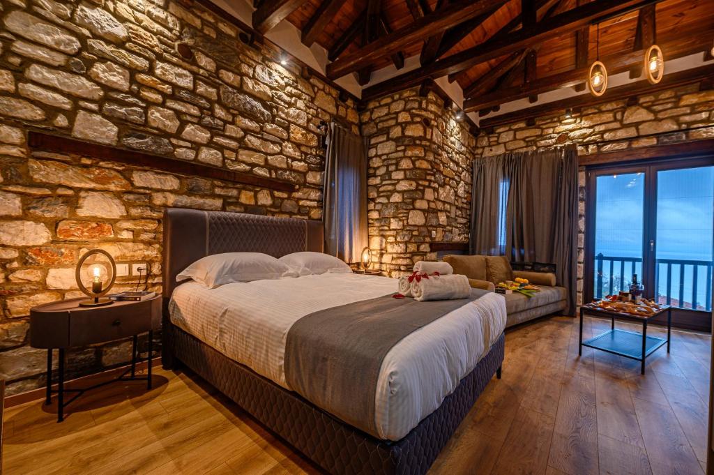 a bedroom with a large bed in a stone wall at Mple Feggari in Mouresi