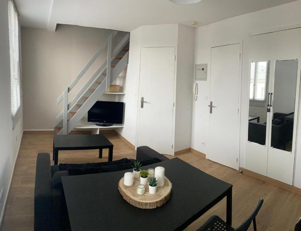 een woonkamer met een bank en een tafel bij Appartement T1B place saint Anne in La Riche