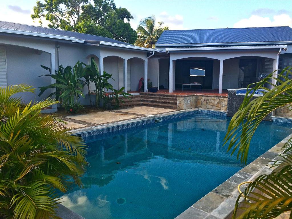 a swimming pool in front of a house at Villa Luxe Mer & Piscine in Sainte-Anne