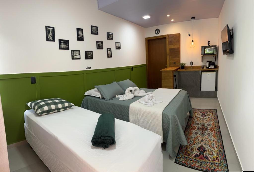2 łóżka w małym pokoju z kuchnią w obiekcie Pousada Águas da Grota w mieście Penha