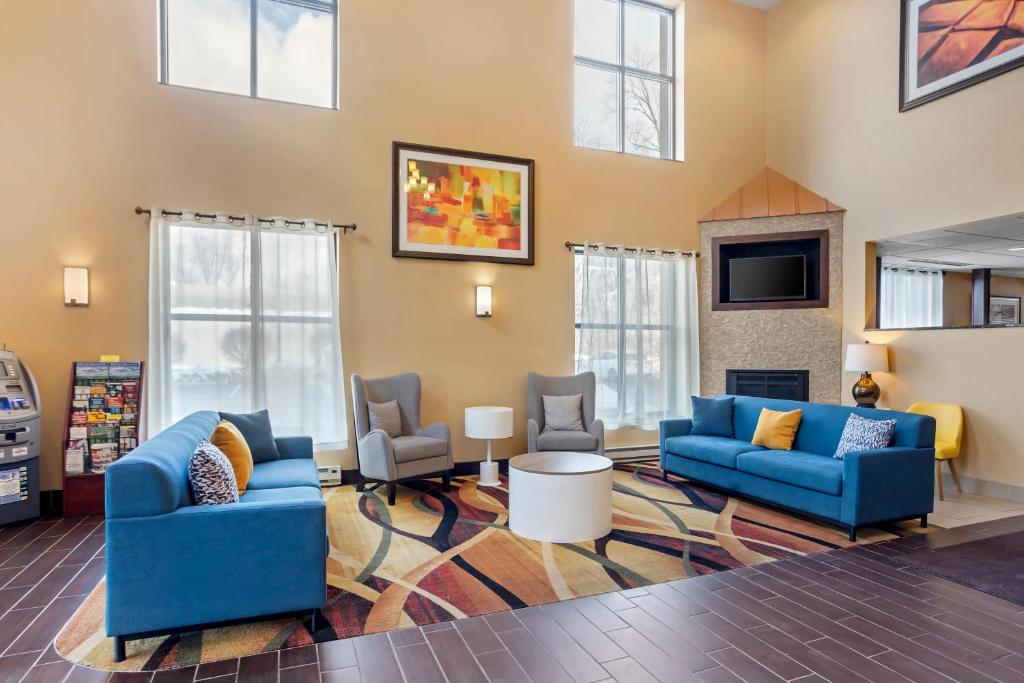 a living room with blue couches and a fireplace at Comfort Inn & Suites in Sayre