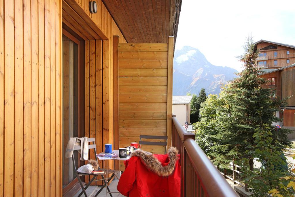 a balcony with a table and a christmas tree at Résidence Provençal by Leavetown Vacations in Les Deux Alpes