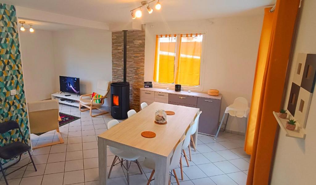 a kitchen and dining room with a table and chairs at Charming house near the sea in Courseulles-sur-Mer