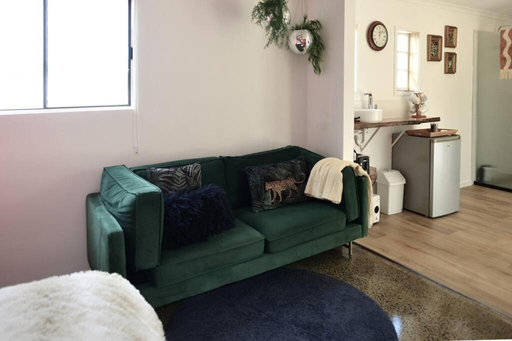 un sofá verde en la sala de estar en Bulimba Studio en Brisbane