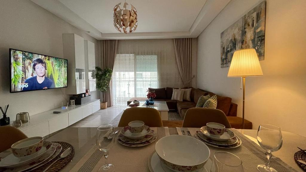 Sidi Daoud的住宿－Schöne, ruhige neuwertige 127qm Ferienwohnung，客厅配有桌椅和电视。