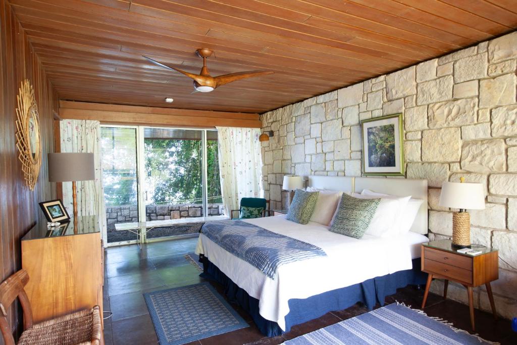 a bedroom with a bed and a stone wall at Frenchman's Cove Resort in Port Antonio