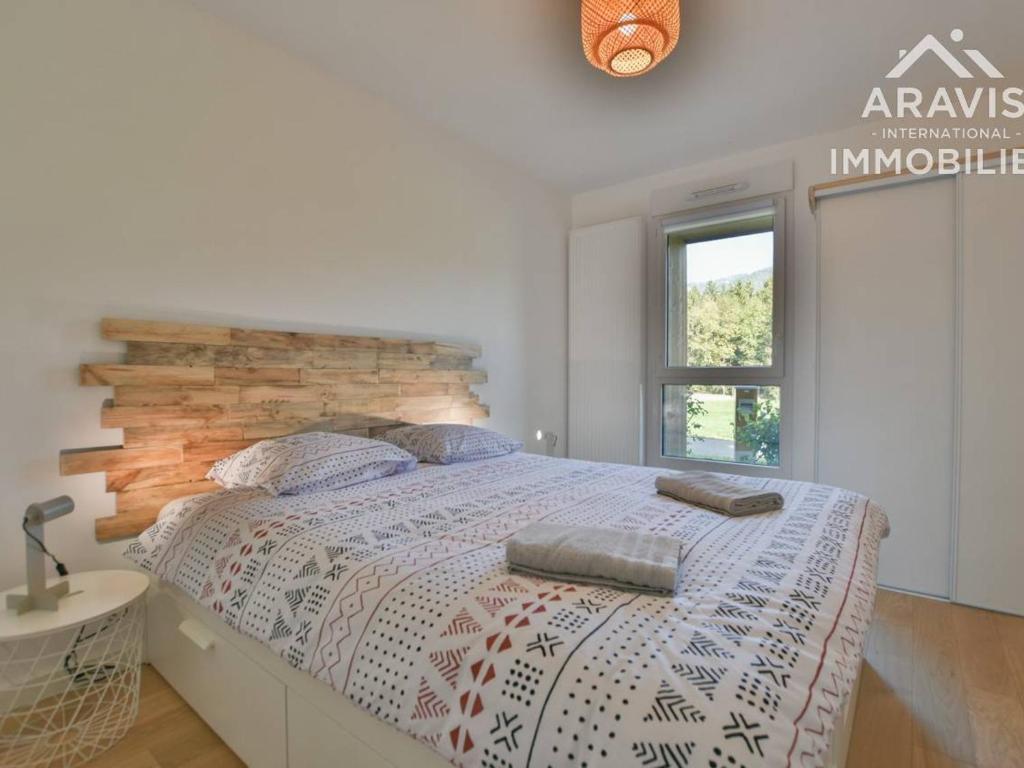 a bedroom with a large bed with a wooden headboard at Appartement Samoëns, 2 pièces, 4 personnes - FR-1-391-178 in Samoëns