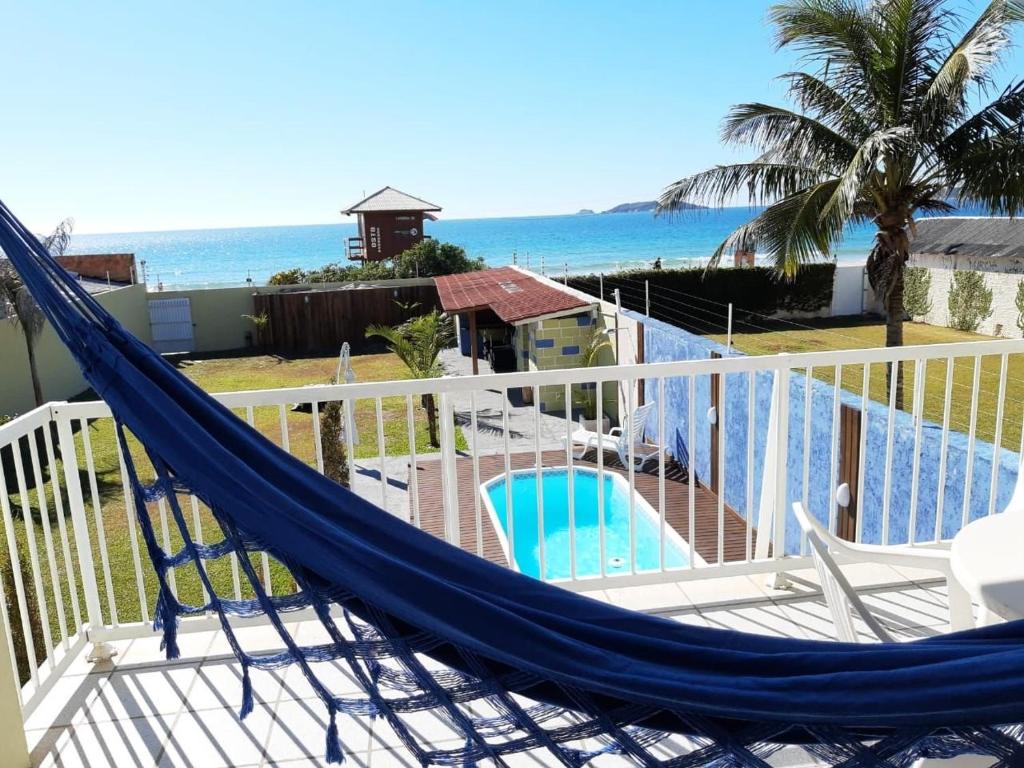 a hammock on a balcony with a view of the ocean at Pousada Ingleses Beach in Florianópolis