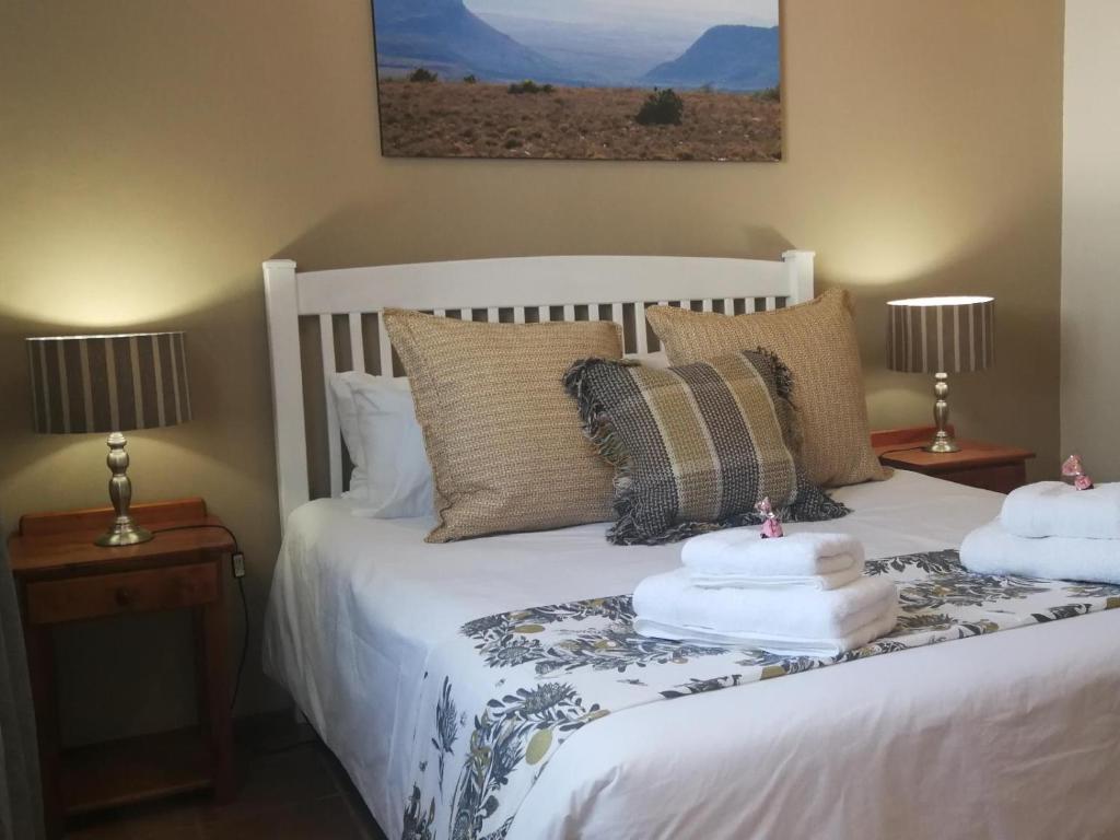 a bedroom with a white bed with two lamps at Rusgenot - Richmond, Karoo in Richmond