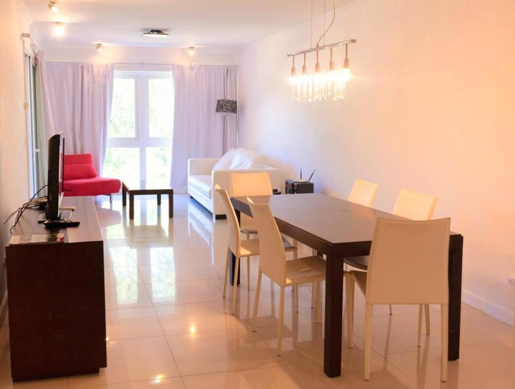 una sala da pranzo e un soggiorno con tavolo e sedie. di Solanas Green park resort and spa Vacation Club a Punta del Este