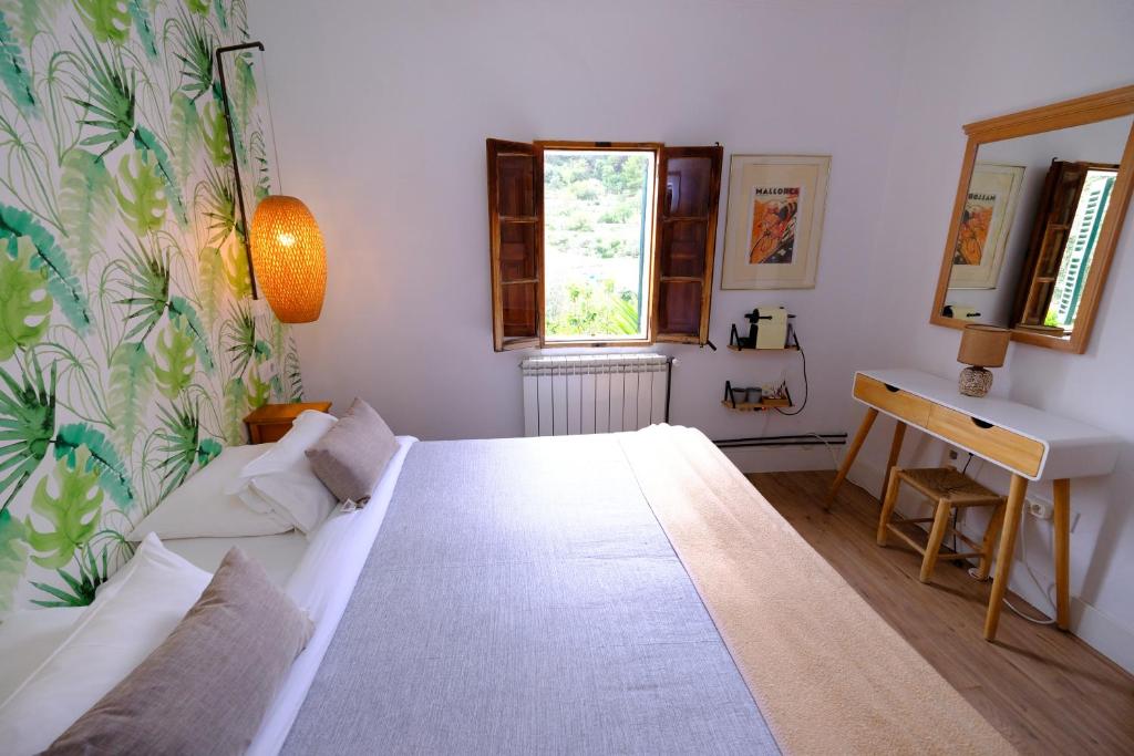 a bedroom with a bed and a desk and a window at Casa Caimari Guest House, for mountain lovers! in Caimari