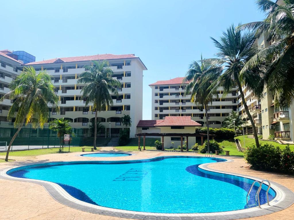 a swimming pool in front of a building with palm trees at Izdisa Muslim Homestay For Muslim Groundfloor Pool view in Port Dickson