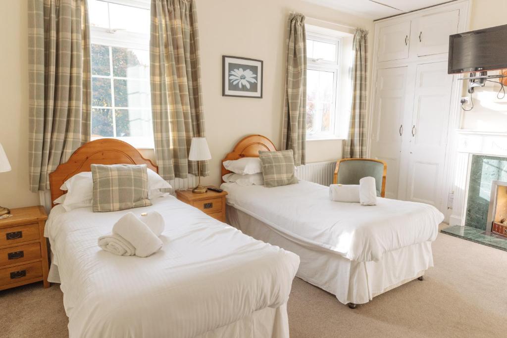 a bedroom with two beds with white sheets at Horton Inn in Horton