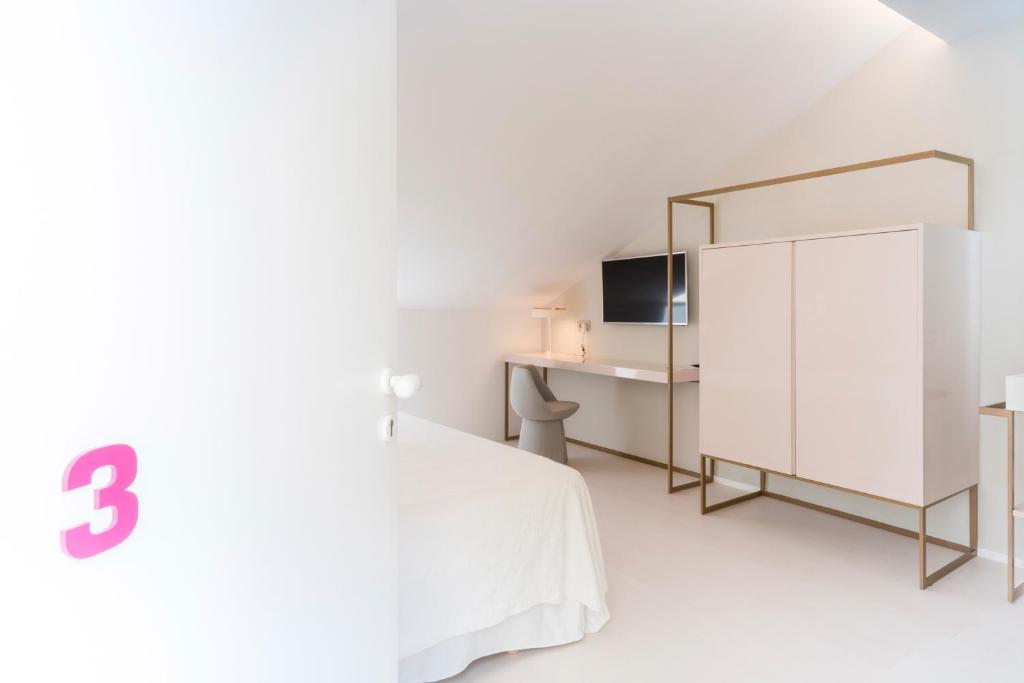 a white bedroom with a white bed and a mirror at Fonda Llabres Boutique in Alcudia