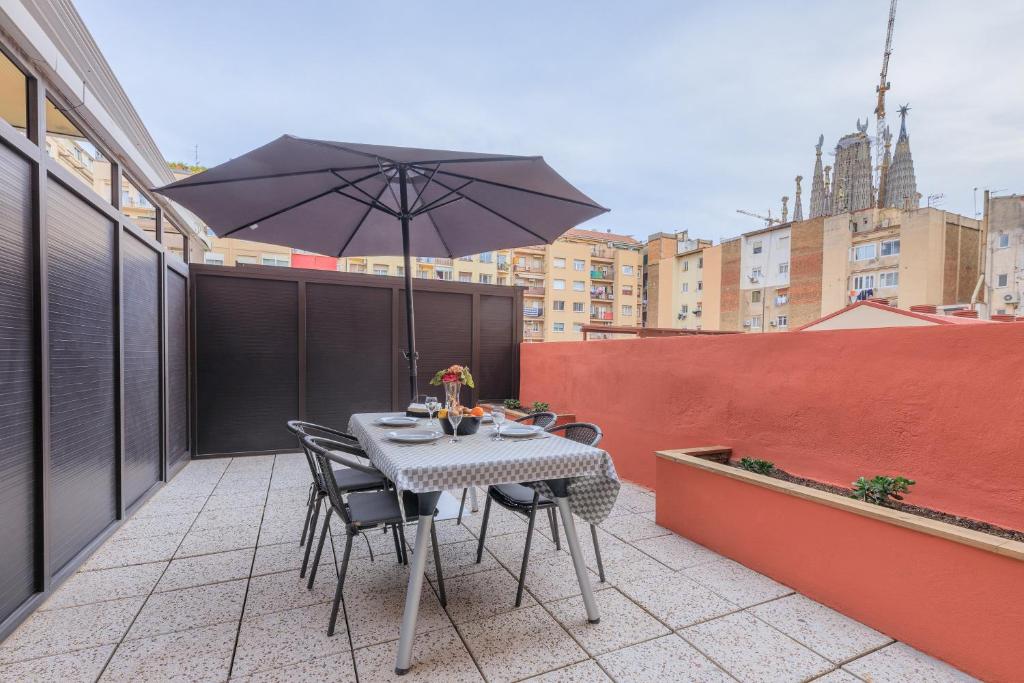 バルセロナにあるStay Barcelona Rosselloのテーブルと椅子、バルコニー(パラソル付)