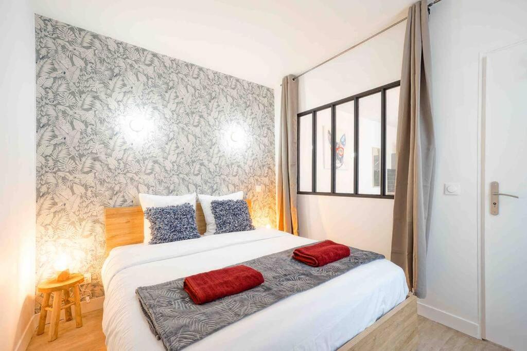 une chambre avec un grand lit blanc avec des oreillers rouges dans l'établissement GRAND BOULEVARD, OPÉRA, suite 1 chambre 2 à 4P, à Paris