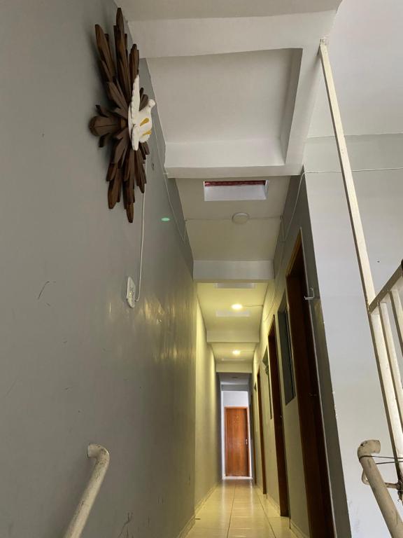 a hallway in a building with a clock on the wall at POUSADA CASA DA FÉ in Aparecida