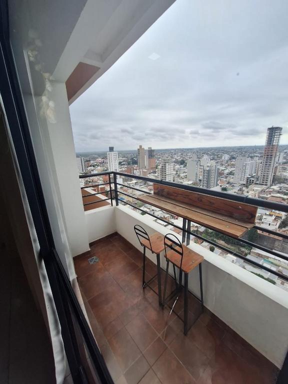 a balcony with two chairs and a view of a city at Departamento 1ero de Mayo (Santa Fe) in Santa Fe