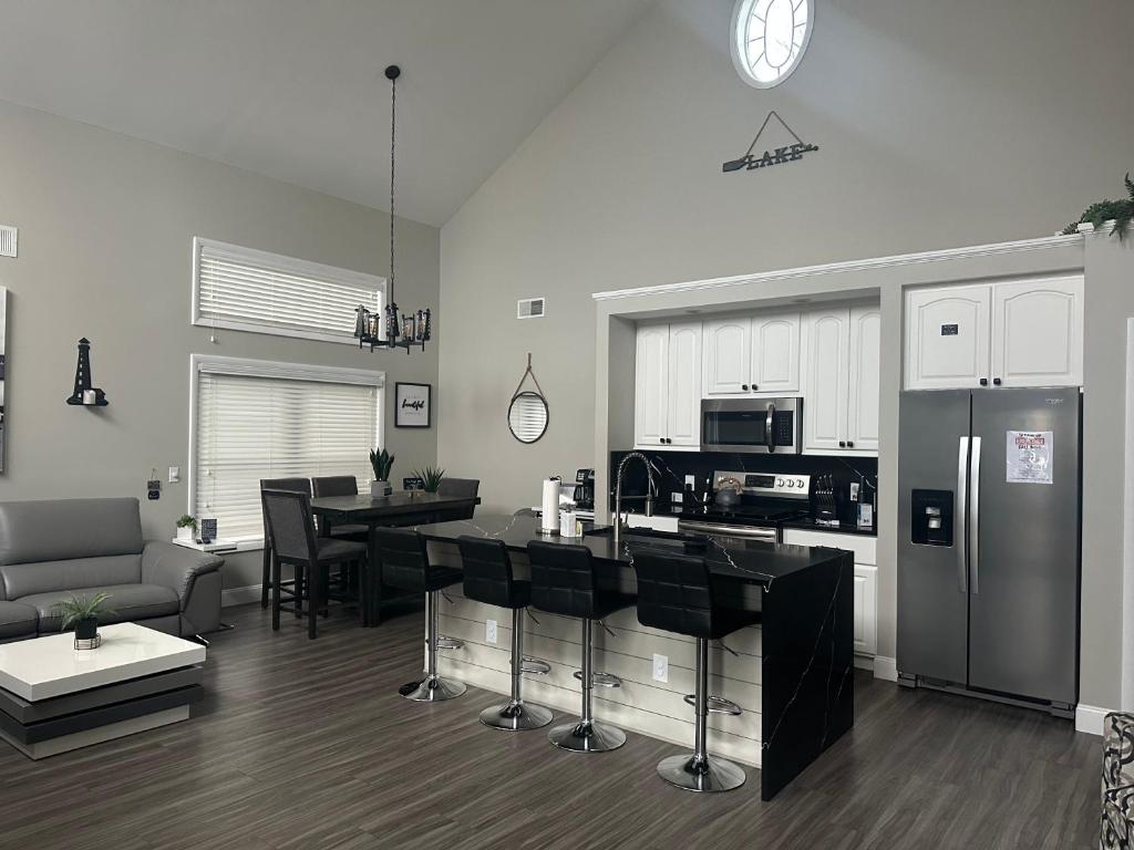a kitchen and living room with a table and a refrigerator at Luxury Lakehouse on Oneida Lake in Blossvale