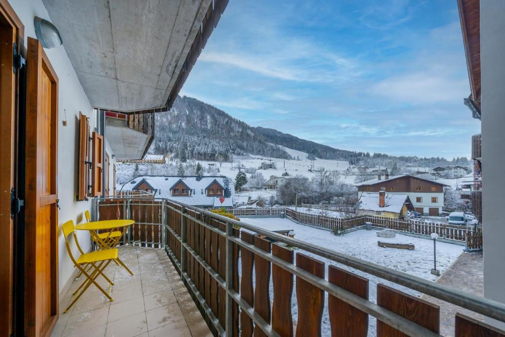 balcón con silla amarilla y vistas a la ciudad en Small & Charming Apt - Overlooking the Alps, en Tarvisio