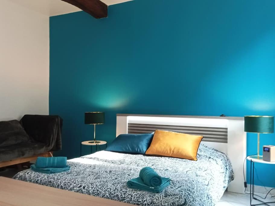 - une chambre avec un mur bleu et un lit dans l'établissement Perle Rare F1 de 43 m quartier historique.(3 p), à Moulins