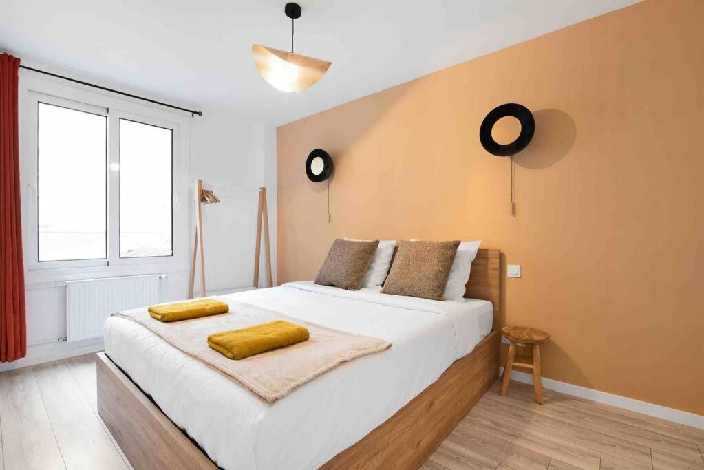1 dormitorio con 1 cama grande y 2 toallas amarillas. en Porte MAILLOT, CHAMPS ÉLYSÉES, TRIOMPHE, suite 3 chambres 8P, en París