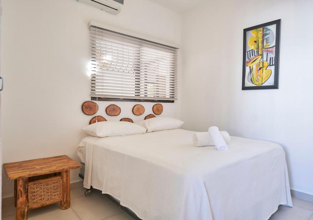 a bedroom with two beds and a table and a window at Heritage Residences Santo Domingo in Santo Domingo