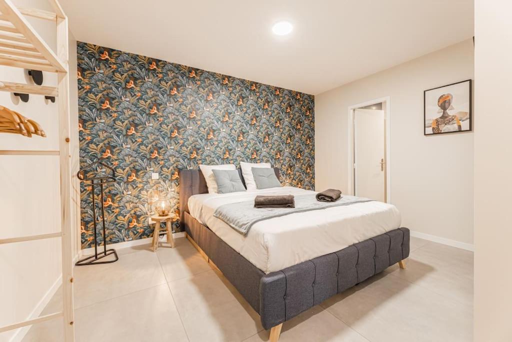 巴黎的住宿－Porte VERSAILLES 15eme, suite 1 chambre 2 à 4P，一间卧室配有一张带花卉壁纸的大床