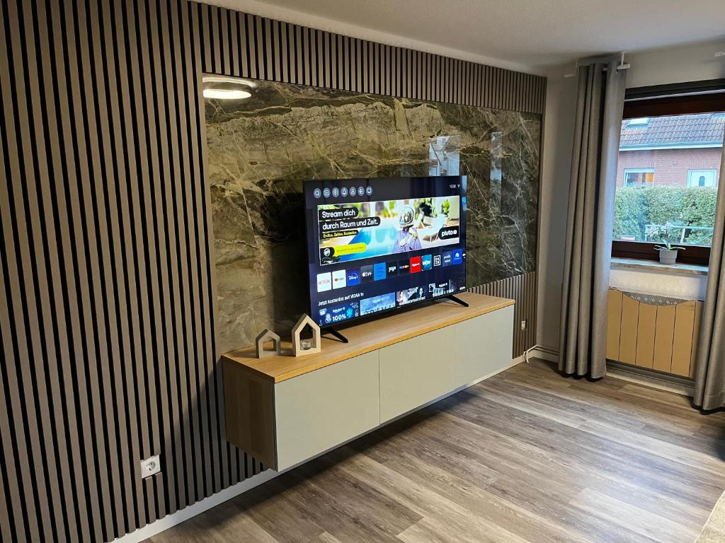 a living room with a flat screen tv in a stone wall at Suite 2 SZ- Lichtenberg in Salzgitter