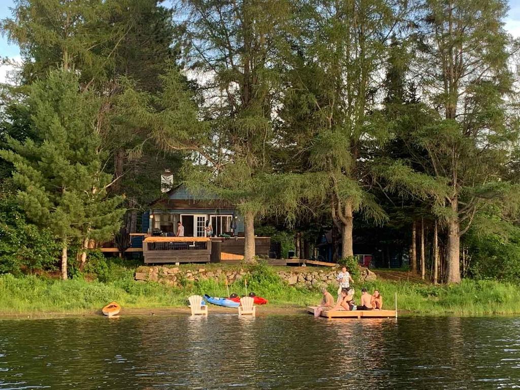 a group of people sitting on boats in the water at Bleu Azur 32 night Lakefront Retreat w Hot tub in Saint Adolphe D'Howard
