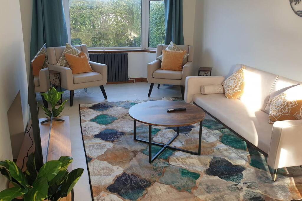 Sala de estar con 2 sofás y mesa en Opulent 4 bed house with parking, en Mánchester