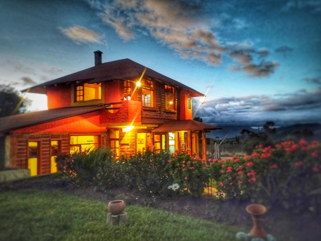 a large house with lights on in the yard at Ruta de los volcanes in Machachi