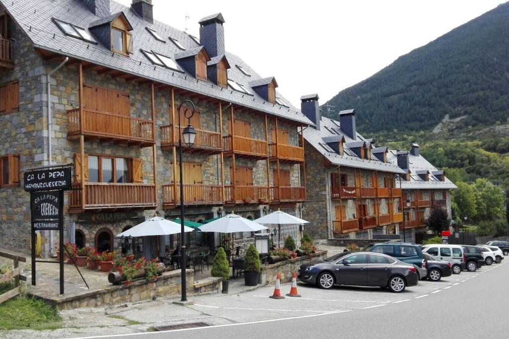 a large building with cars parked in front of it at Duplex en la Vall de Boí, plena naturaza in Bohí